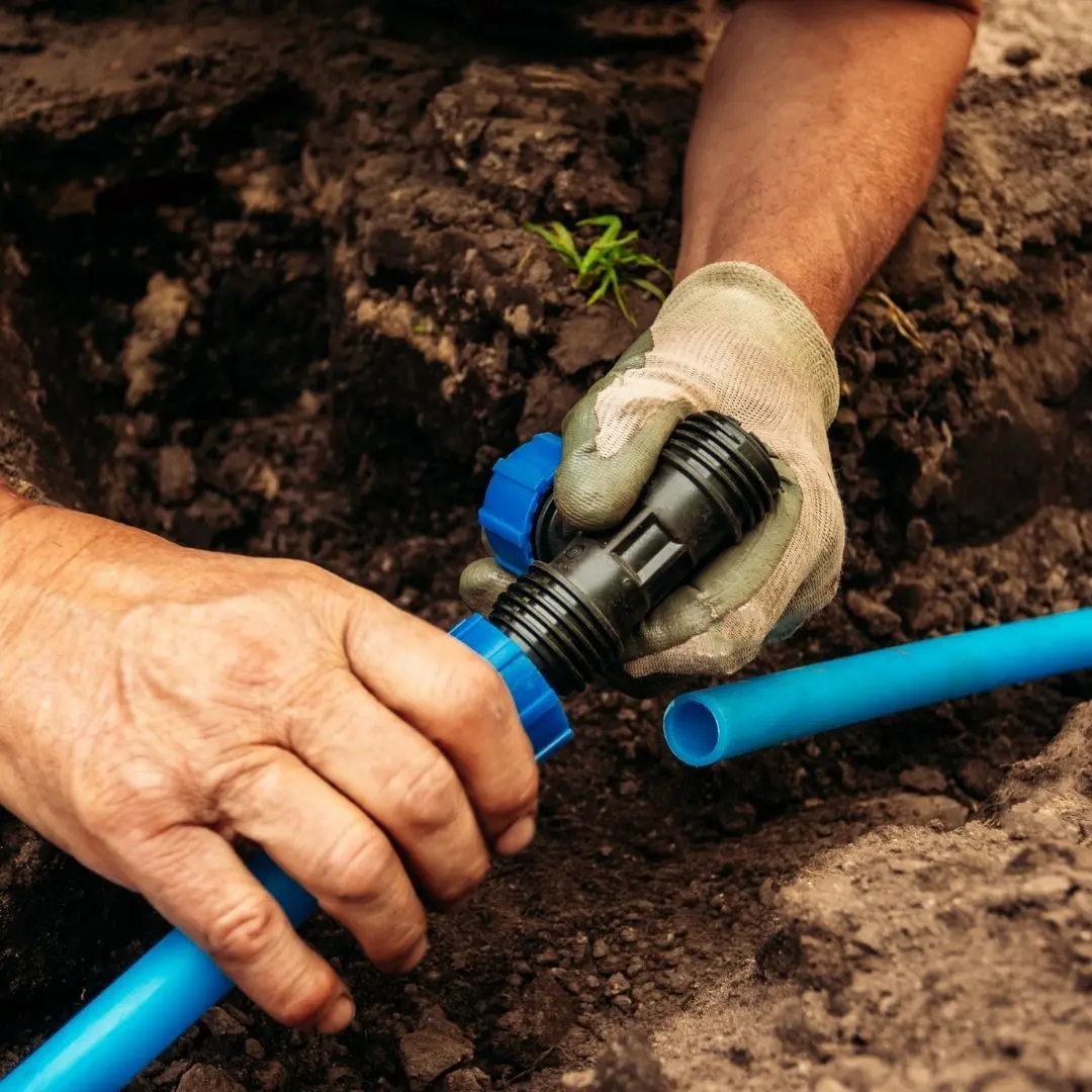 Technician connecting blue drip line fittings while installing a smart irrigation system in Columbus, GA Technician connecting blue drip line fittings while installing a smart irrigation system in Columbus, GA